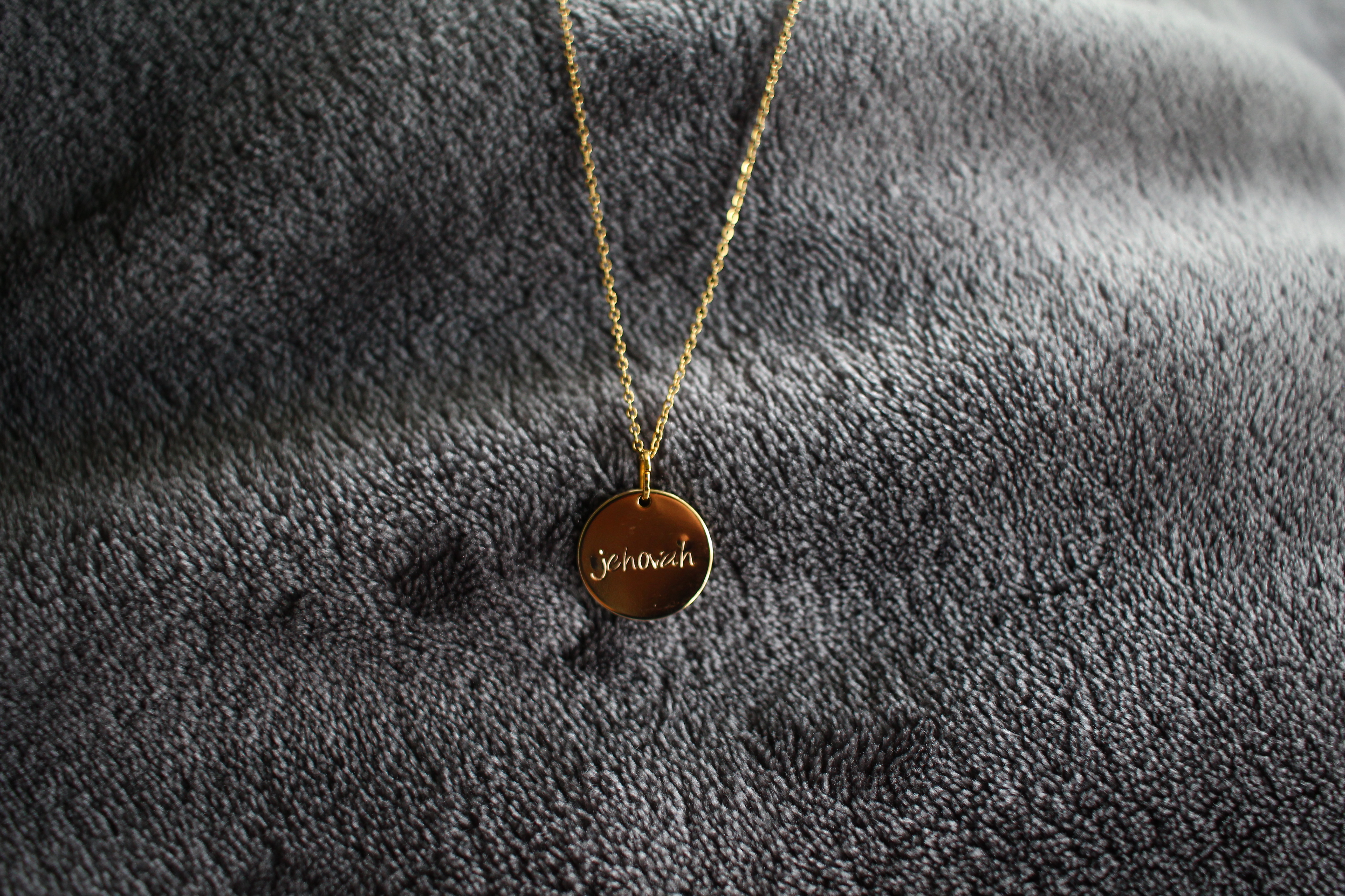 Gold necklace with 'Jehovah' written on it